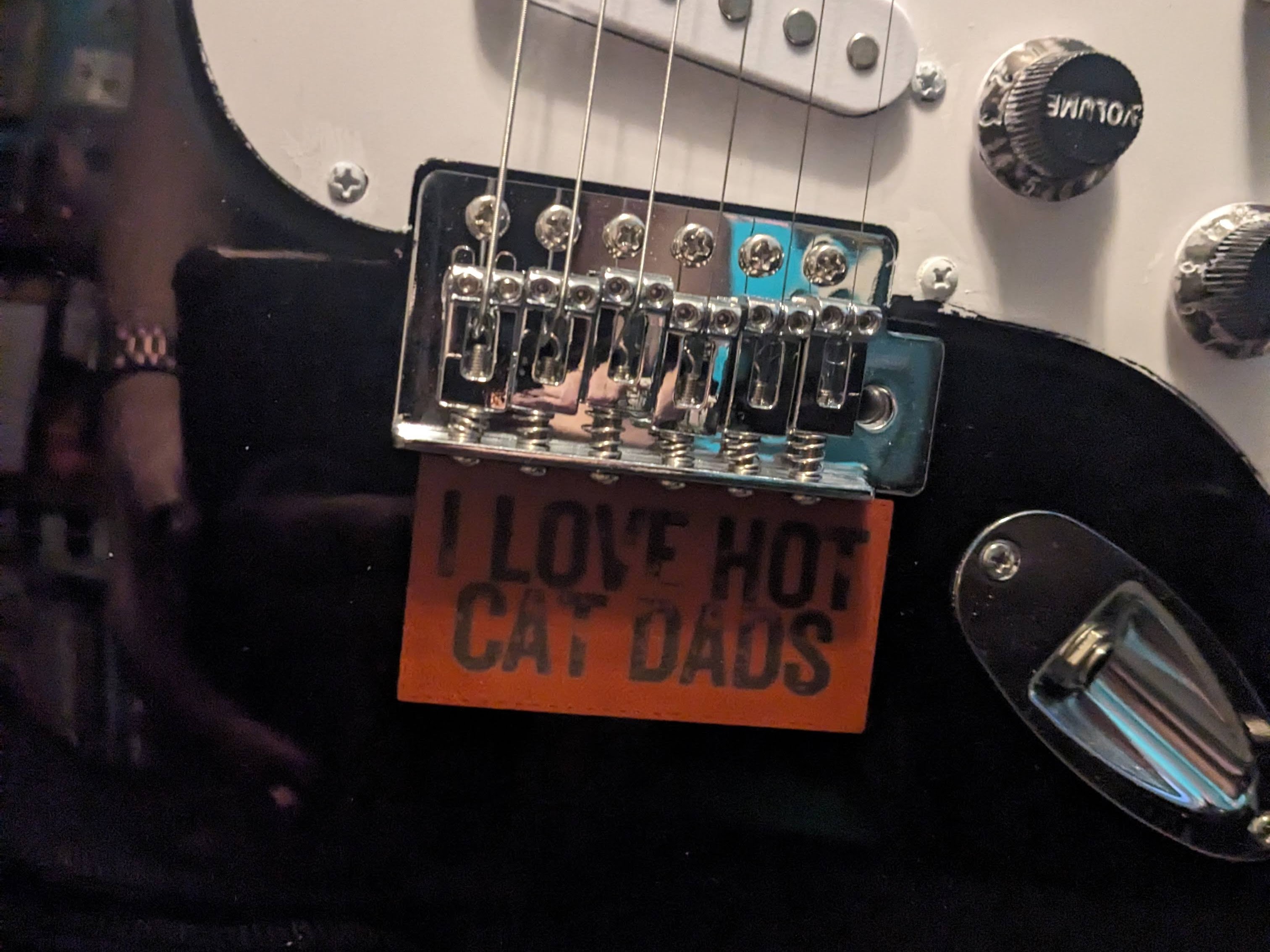 A patch on a guitar that says I love hot cat dads