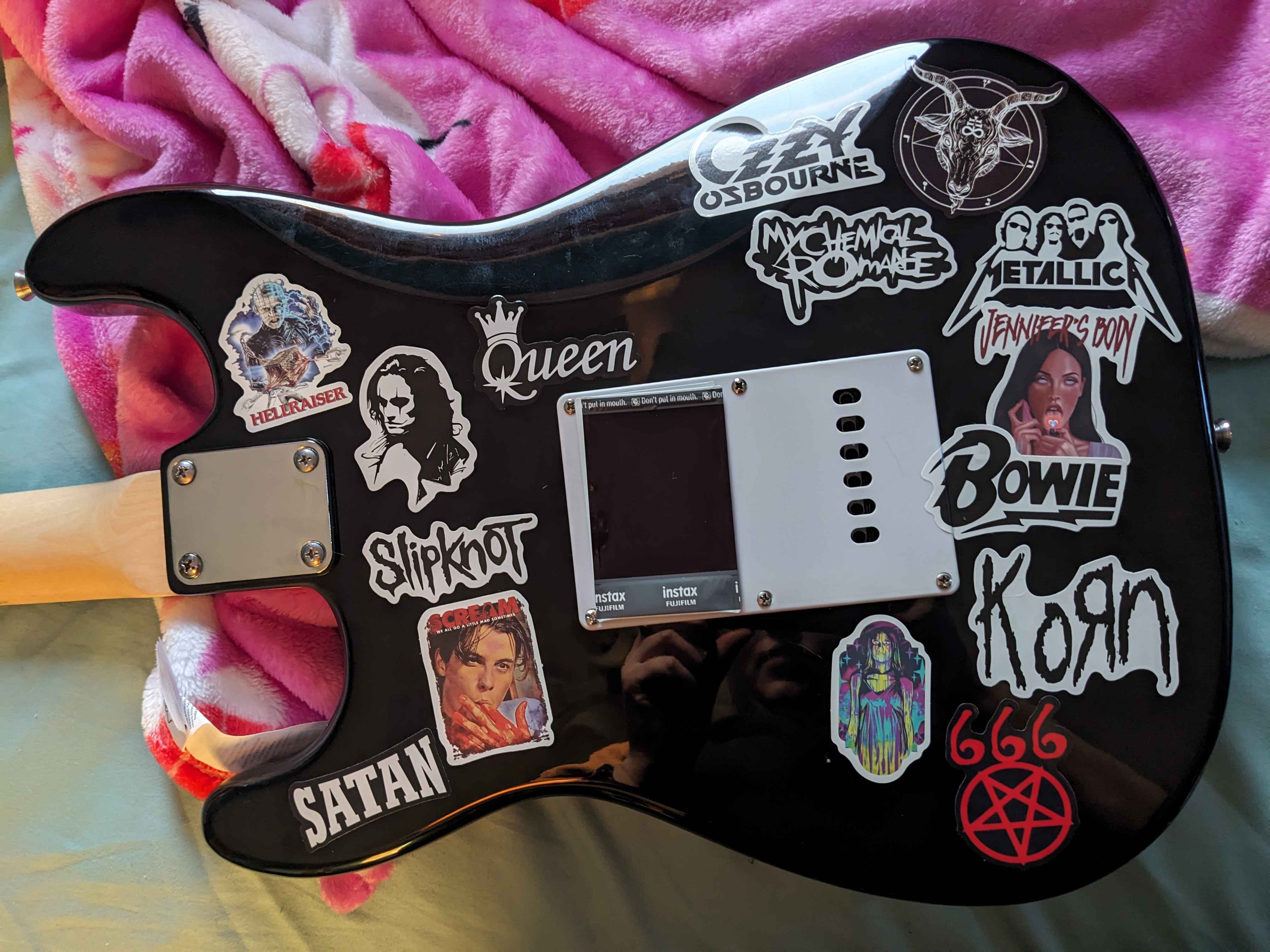 The back of a guitar, covered in stickers